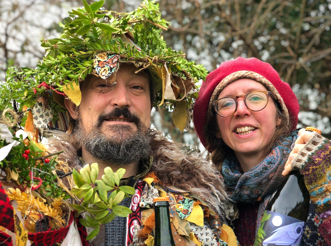 Two people stand dressed in green foliage and wassail costumes