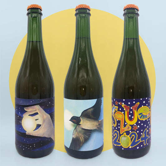 Three green bottles with artistic labels on a light blue background