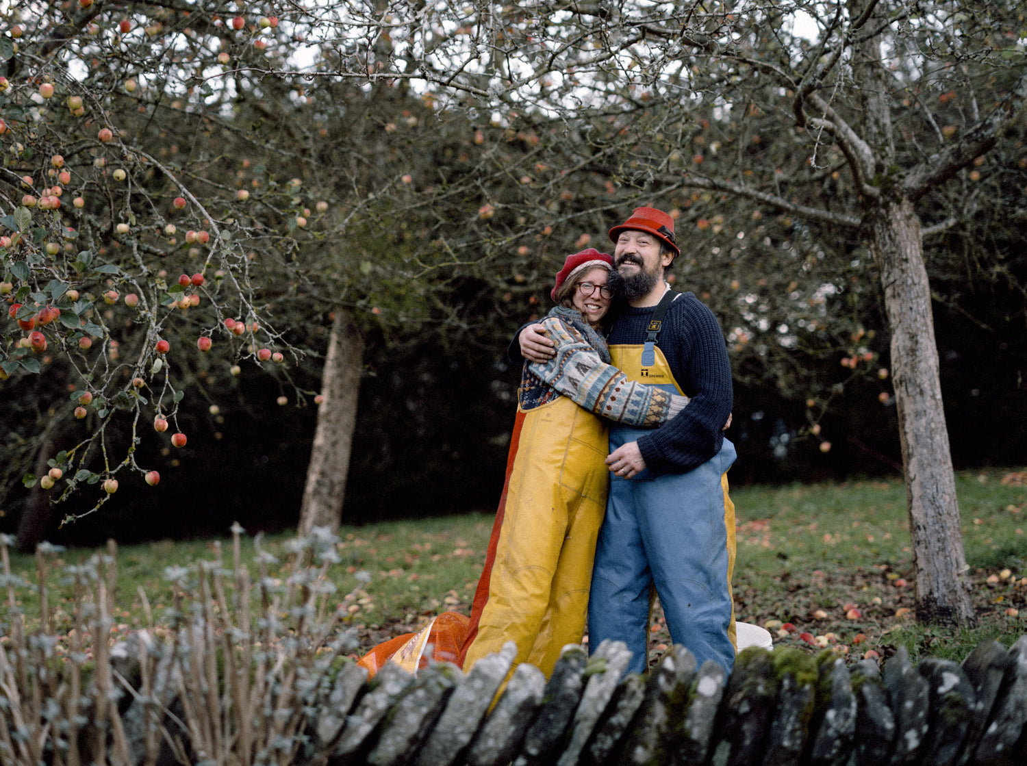 Two people hugging in an orchard in late Autumn